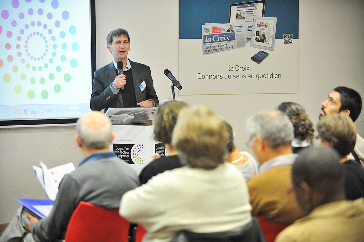 Stéphane Le Blanc, directeur de Bayard Service lors du séminaire interne de Bayard Service (2013). Fond d’écran, habillage pupitre et badge. Crédit photo : Corinne Simon